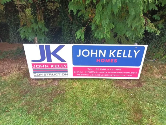 A photograph showing a John Kelly Construction and John Kelly Homes sponsorship board on the Bangor Cricket Club grounds.