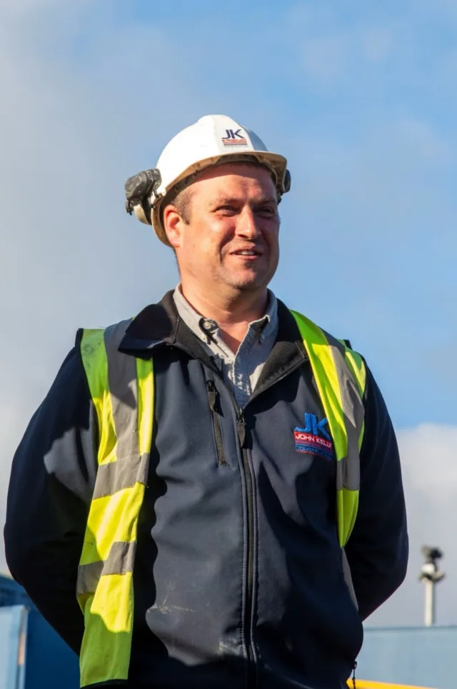 Photograph of James, our site manager, wearing a hard hat and a high-vis vest.